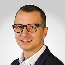 Twarz młodego uśmiechniętego mężczyzny.